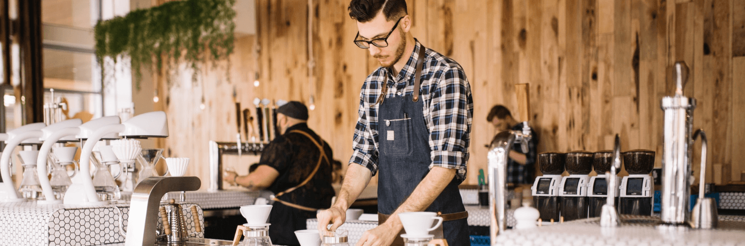 A staffer brewing coffee